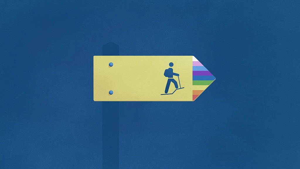 Un panneau de signalisation de chemin de randonnée suisse indique la direction à suivre. L'extrémité de la flèche est colorée aux couleurs de l'arc-en-ciel. Ce panneau symbolise le chemin vers l'égalité des personnes LGBTIQ.